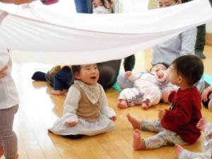 布の下に入って遊ぶ赤ちゃん