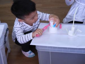 紙コップに絵を描いている子どもの写真