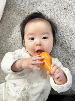 おもちゃのチキンを手に持つ赤ちゃん