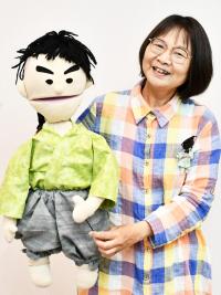 人形劇の人形おじかくんを持って笑顔の杉山さん