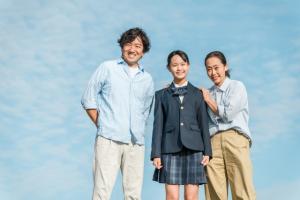 女子学生と両親のイメージ写真