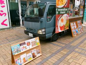 キッチンカー横に設置した面展台の本の写真
