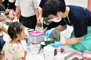 石こうを練る様子を見つめる女の子