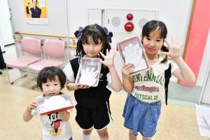 できた手形を持つ笑顔の子どもたち