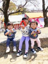二の丸公園の石の上に座る幼い三姉妹