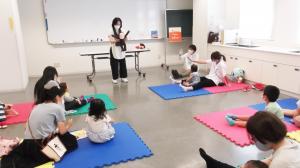 ちいさなおはなし会で、親子でマットの上に座り、お話を聞く様子