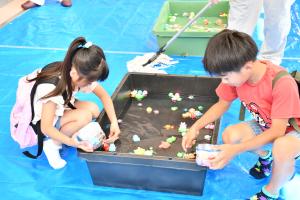 光る金魚すくいをする子どもたち