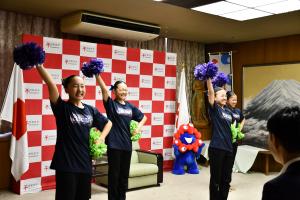 右手を挙げ、ポーズをとる4人の選手