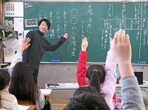 黒板を背に小学生に教える男性講師
