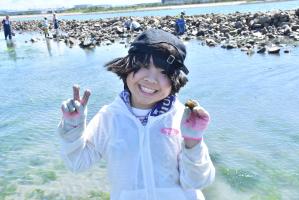 手に貝を持ち笑顔の子ども