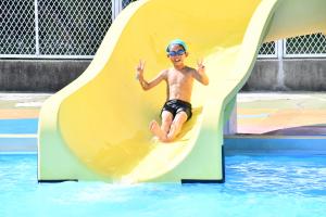 プールの滑り台で遊ぶ男の子