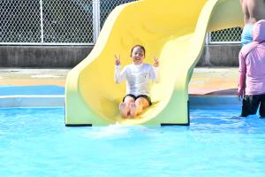 プールの滑り台で遊ぶ女の子