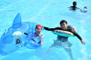 大きなシャチの浮き輪で遊ぶ親子