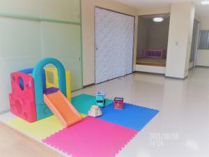 山直地区公民館　１階保育室内　遊具と畳の部屋（奥にベビーベッドあり）