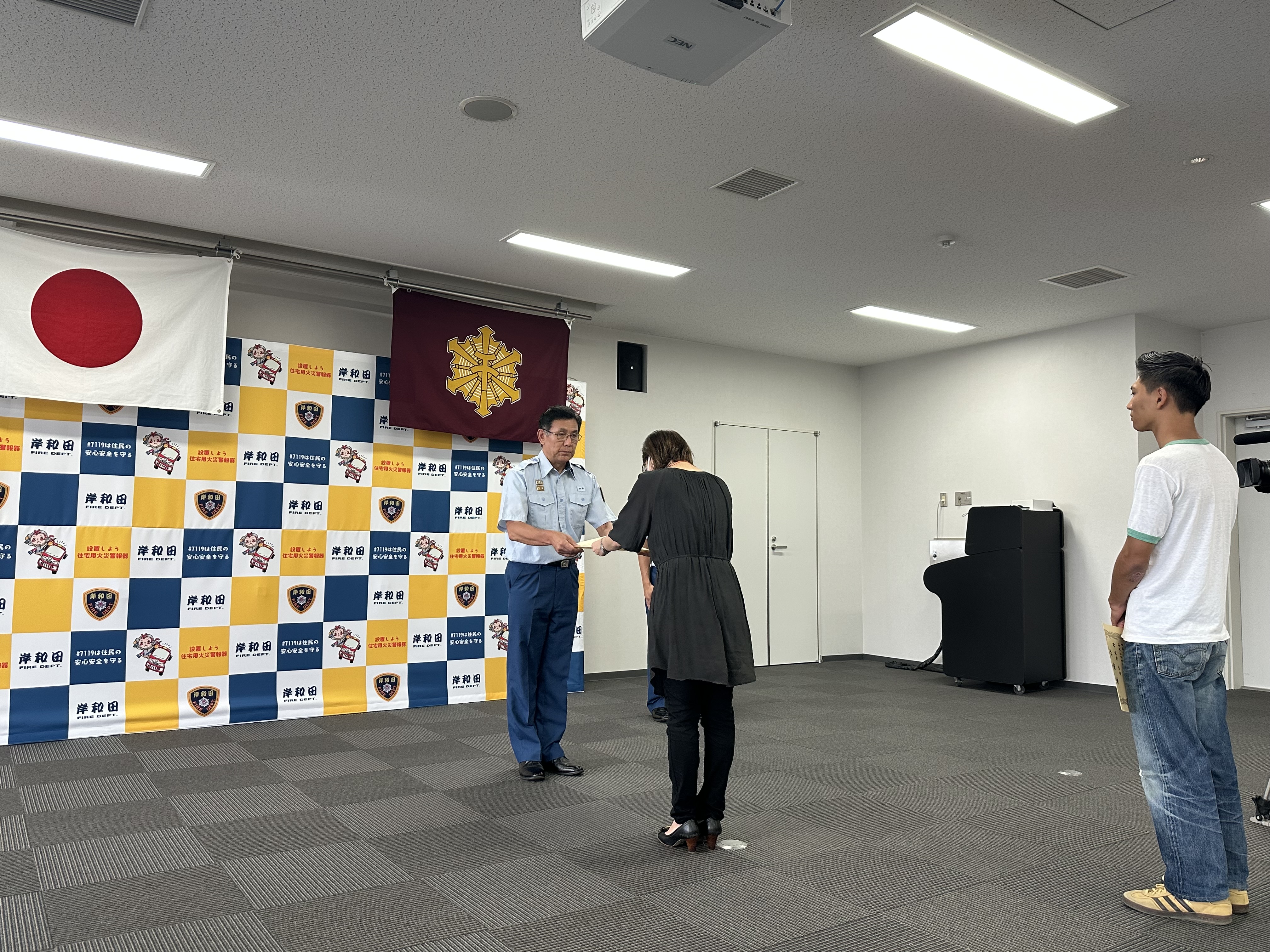 市役所女性職員が消防長から感謝状を受け取る写真