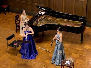 ピアノと管楽器を演奏する3人