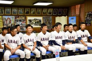 椅子に座る野球少年たち