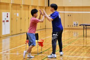 ハイタッチをする参加者の男性とスタッフ