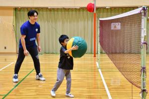 大きなボールを持って顔が隠れそうな小学生の男の子