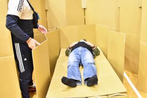 ダンボールベッドに寝転ぶ男性