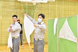 三角巾の使い方を説明する消防職員