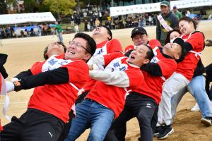 歯を食いしばって綱引きをする男性たち