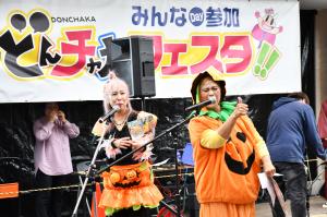 かぼちゃの衣装を着て歌う女性２人