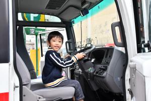 大きな車の運転席に座る子ども
