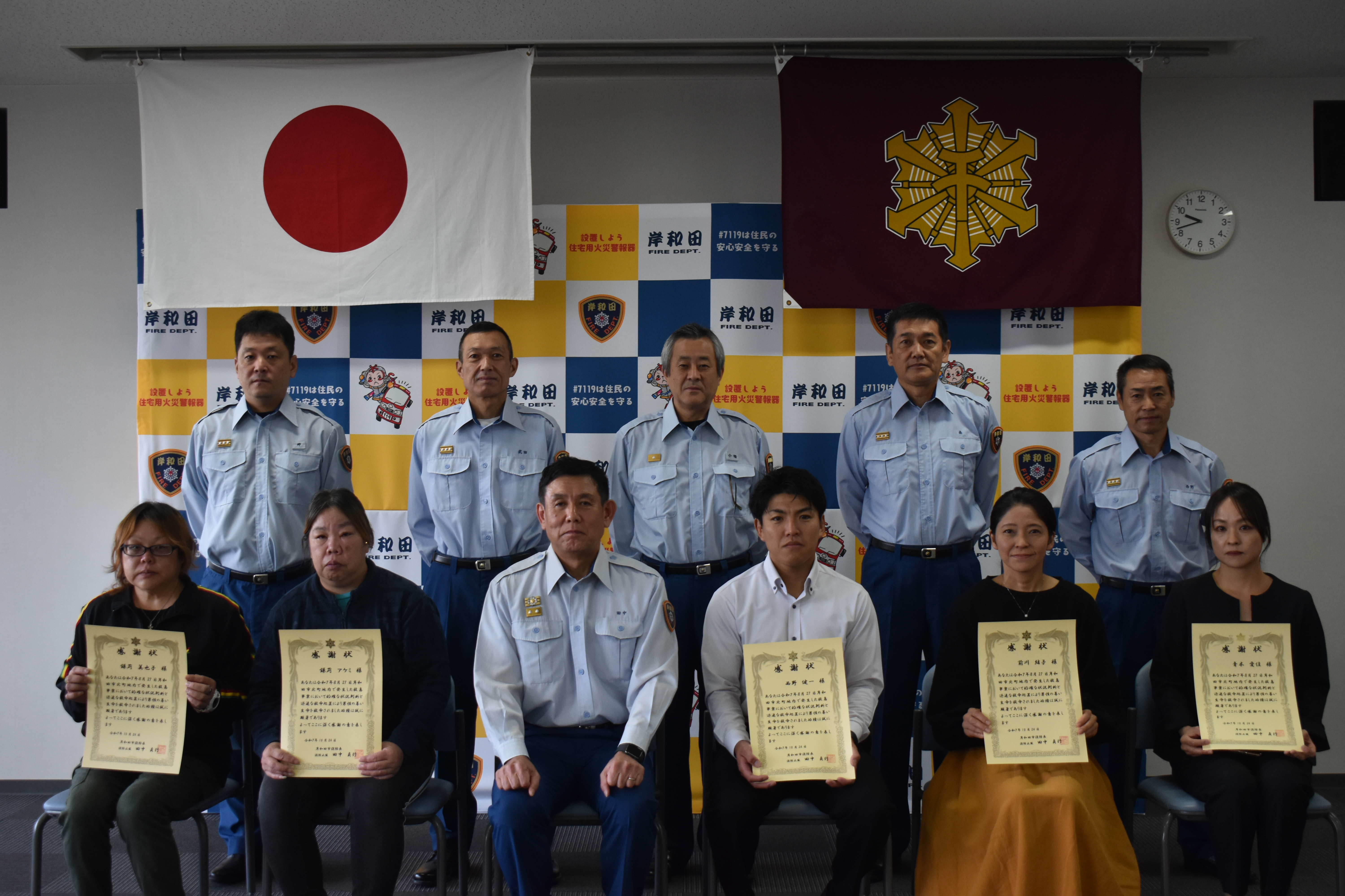 消防協会者5名と消防長と各課長が並んでいる写真
