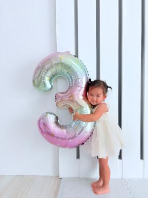 3の形をした風船を持つ女の子