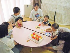 テーブルを囲む幼児とその保護者達