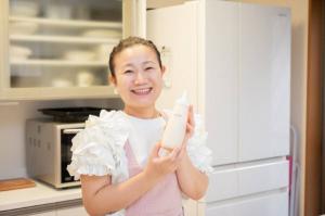 ピンク色のエプロンを付けた女性