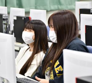 授業中、笑顔の女子生徒2人