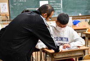 つきっきりで教える先生と男子生徒