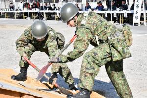 スコップで土を払う自衛隊員