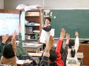 手を挙げている小学生と先生