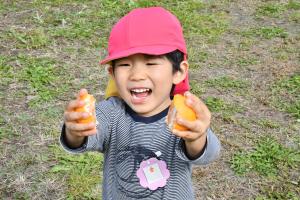 みかんをカメラに見せてくれる園児