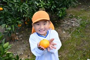 みかんをカメラに見せてくれる園児