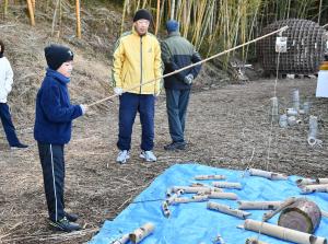 竹製の魚釣りをする男の子