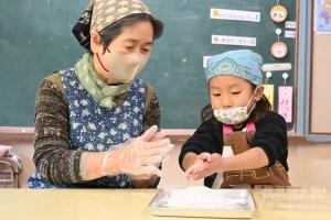 おばあちゃんと一緒におもちを丸める女の子