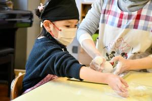 楽しそうにおもち丸めをする女の子