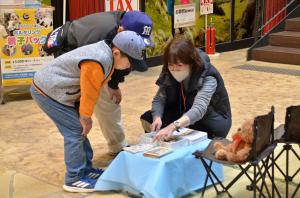 絵本コーナーで説明を聞く小学生の兄弟