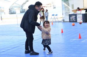 お父さんと一緒にスラロームシュートにチャレンジする小さな女の子