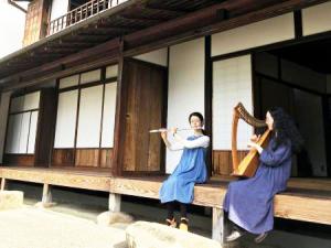 縁側でフルートとハープを演奏する行灯社のお二人