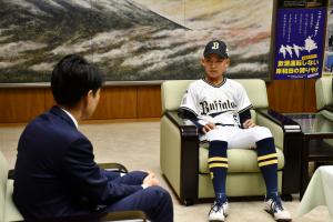 椅子に座って対談している様子