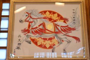 白い馬が赤色と金色の装飾を纏っている写真