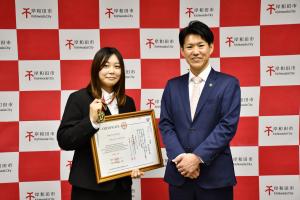 賞状とメダルを持って市長と記念撮影をする豊島さん