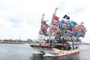 沢山の大漁旗を掲げ海上を進む船