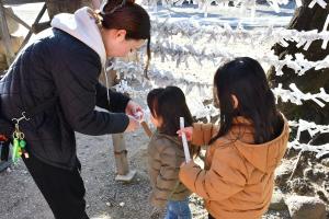 おみくじを見るお母さんと幼い姉妹