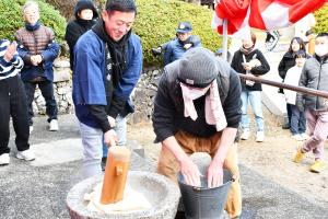 餅をつく法被姿の男性